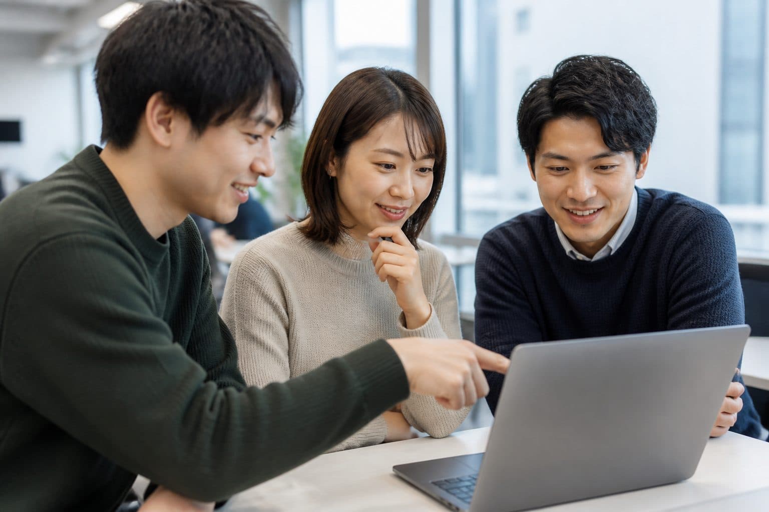 ノートPCを囲んで相談するメンバーのイメージ